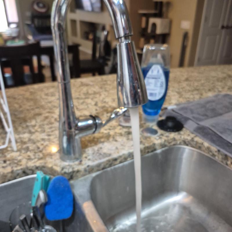 Kitchen sink faucet with running water in granite countertop Kitchen sink faucet with running water in granite countertop