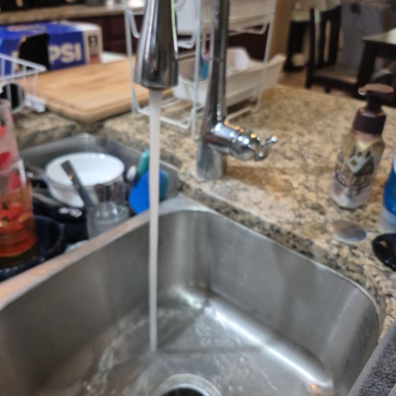 Kitchen sink faucet with running water on granite counter Kitchen sink faucet with running water on granite counter