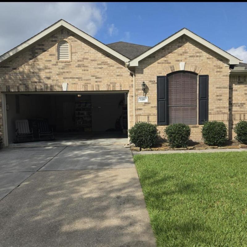 Garage door and driveway view of brick home exterior