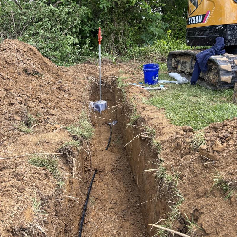 Water hydrant installation trench with excavator nearby Water hydrant installation trench with excavator nearby