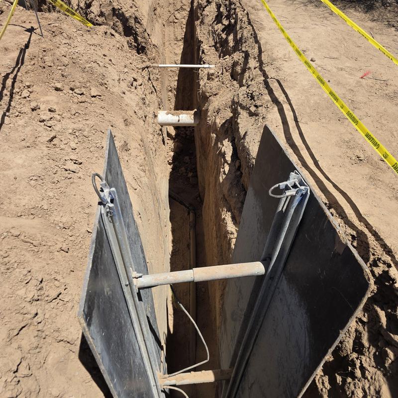Sewer line trench with safety shoring panels Sewer line trench with safety shoring panels