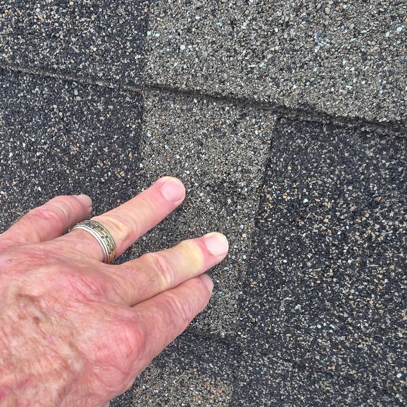 Asphalt roof shingle with hail damage close-up