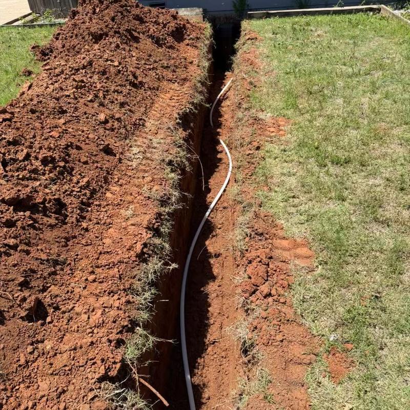 Water service line trench with new pipe installation in yard