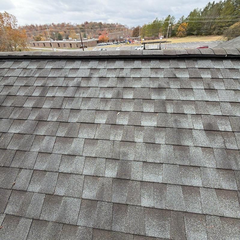 Asphalt shingle roof with hail damage on church ridge