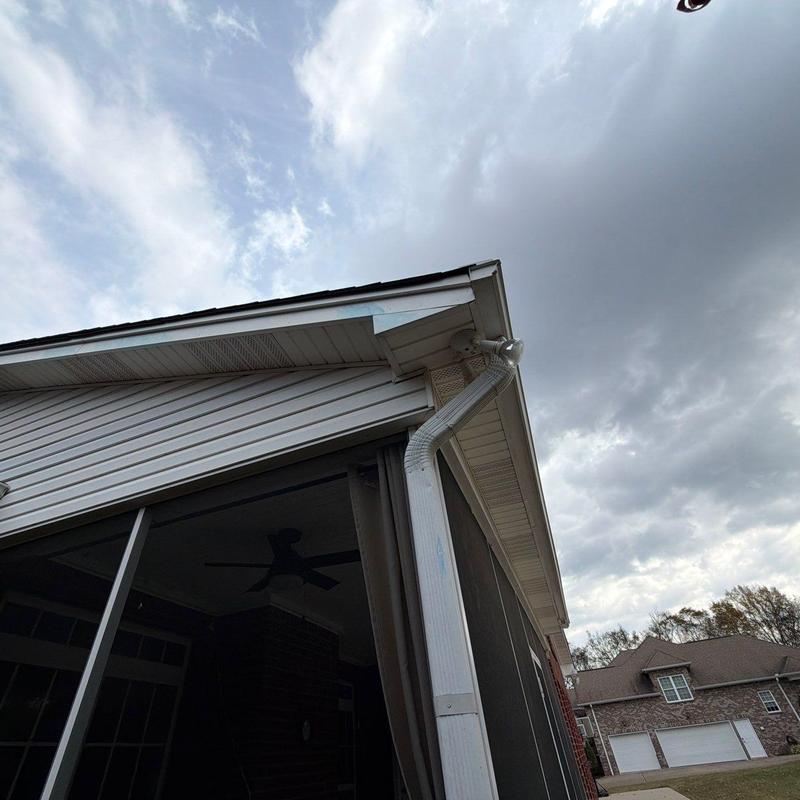 Gutter downspout and roof soffit inspection under cloudy sky