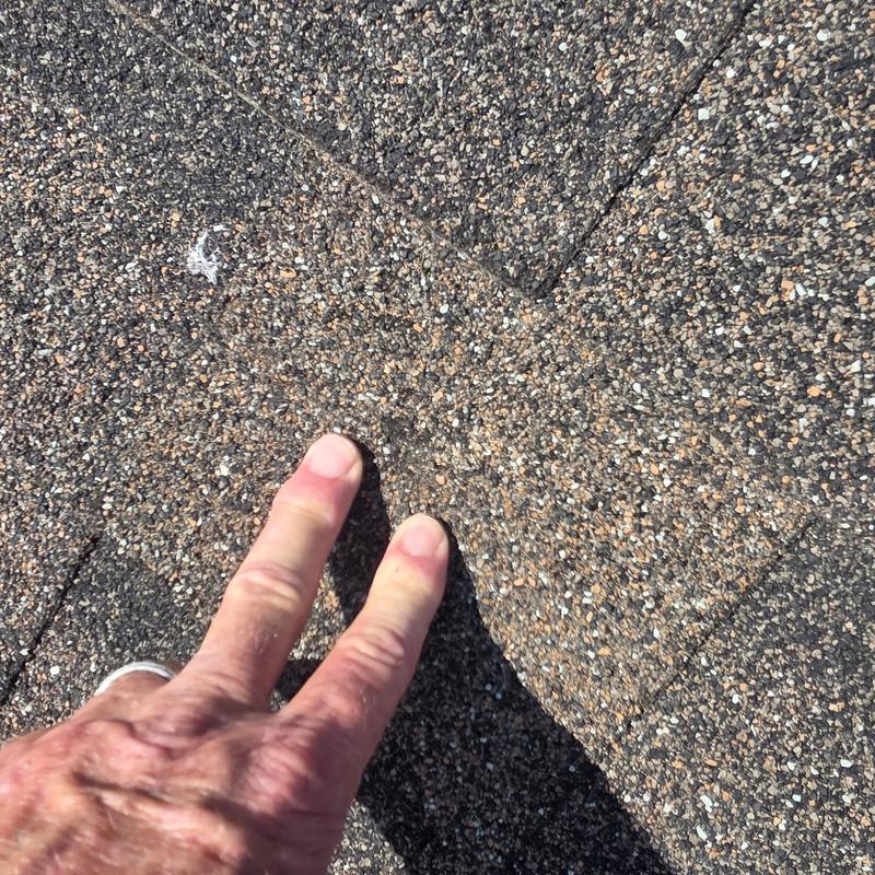 Roof shingles with hail damage and inspection fingers