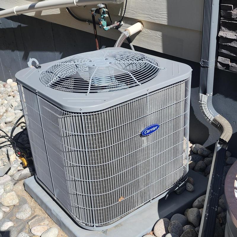 Carrier outdoor air conditioner condenser unit on stone bed