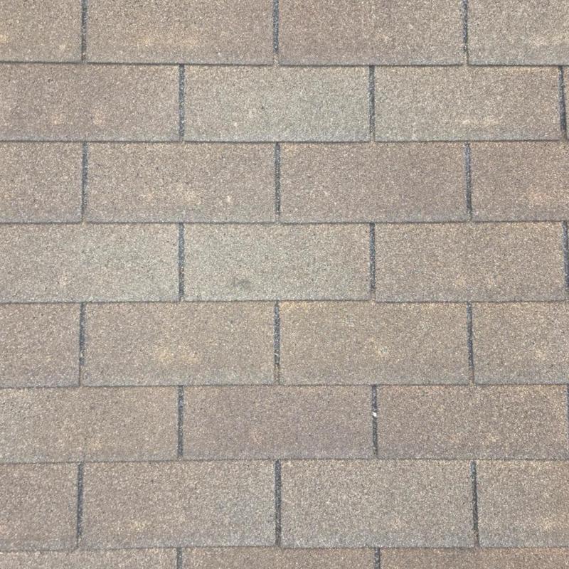 Asphalt roof shingles showing granule loss and hail marks Asphalt roof shingles showing granule loss and hail marks