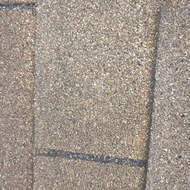 Asphalt roof shingles with granule wear close-up Asphalt roof shingles with granule wear close-up