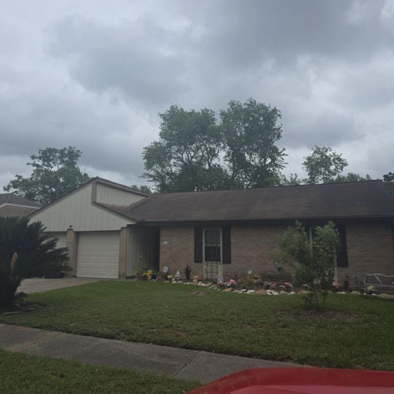 Residential asphalt shingle roof with storm damage signs Residential asphalt shingle roof with storm damage signs