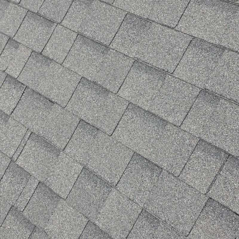 Asphalt roof shingles with visible hail damage