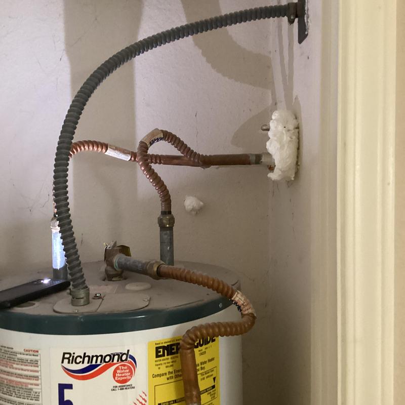 Electric water heater piping and wall sealant in closet Electric water heater piping and wall sealant in closet