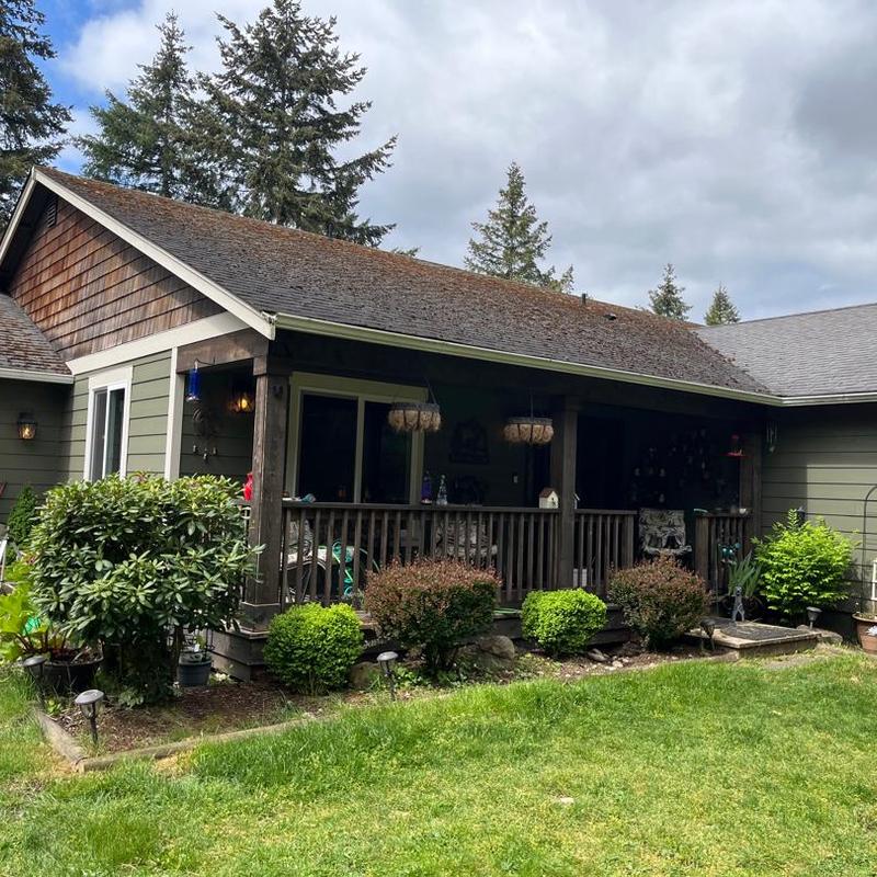 Asphalt shingle roof on residential house with porch Asphalt shingle roof on residential house with porch