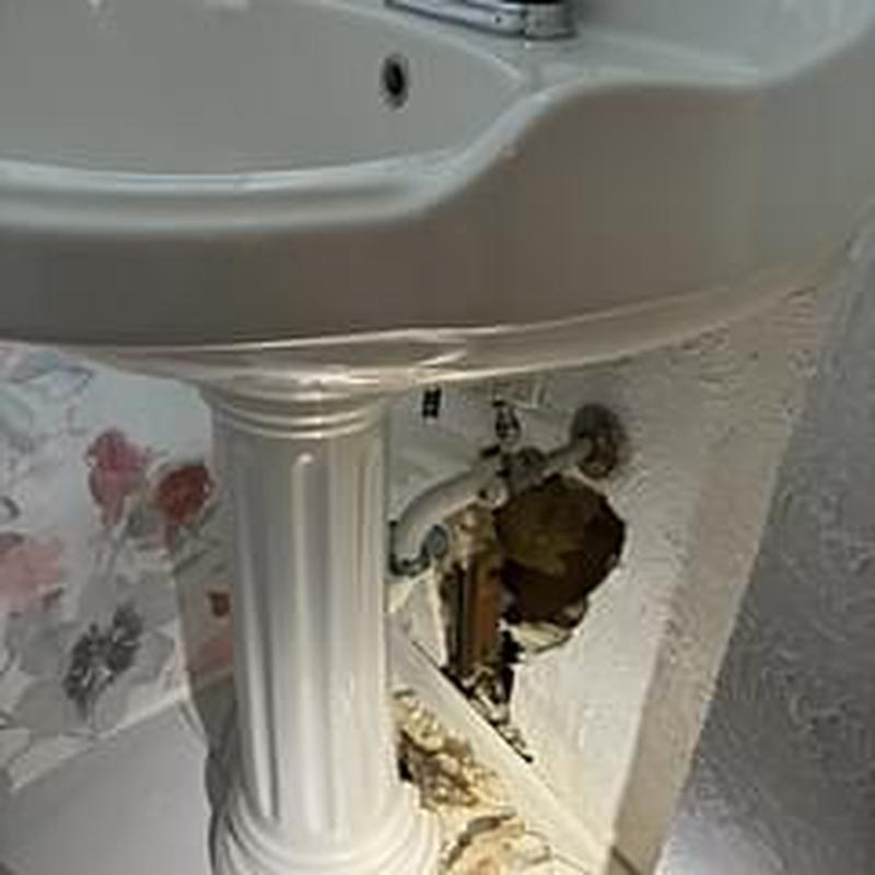 PVC sink drain pipe with wall cutout and new trap installation