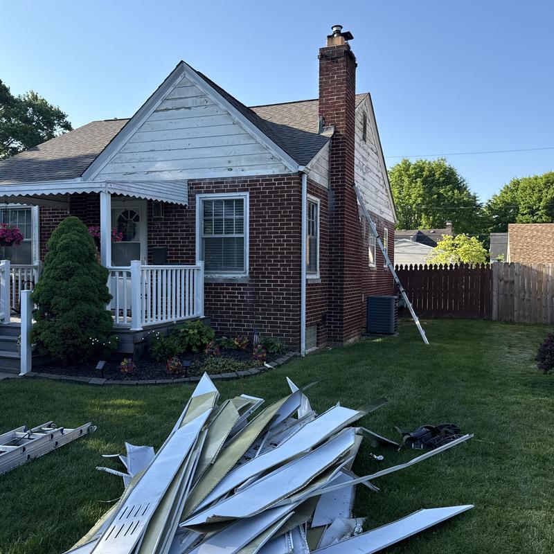 Aluminum siding removal with ladder beside brick house Aluminum siding removal with ladder beside brick house