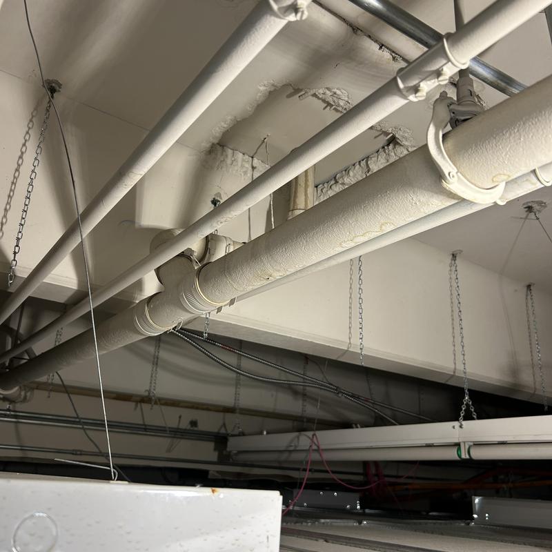Commercial mainline plumbing pipes overhead in ceiling space
