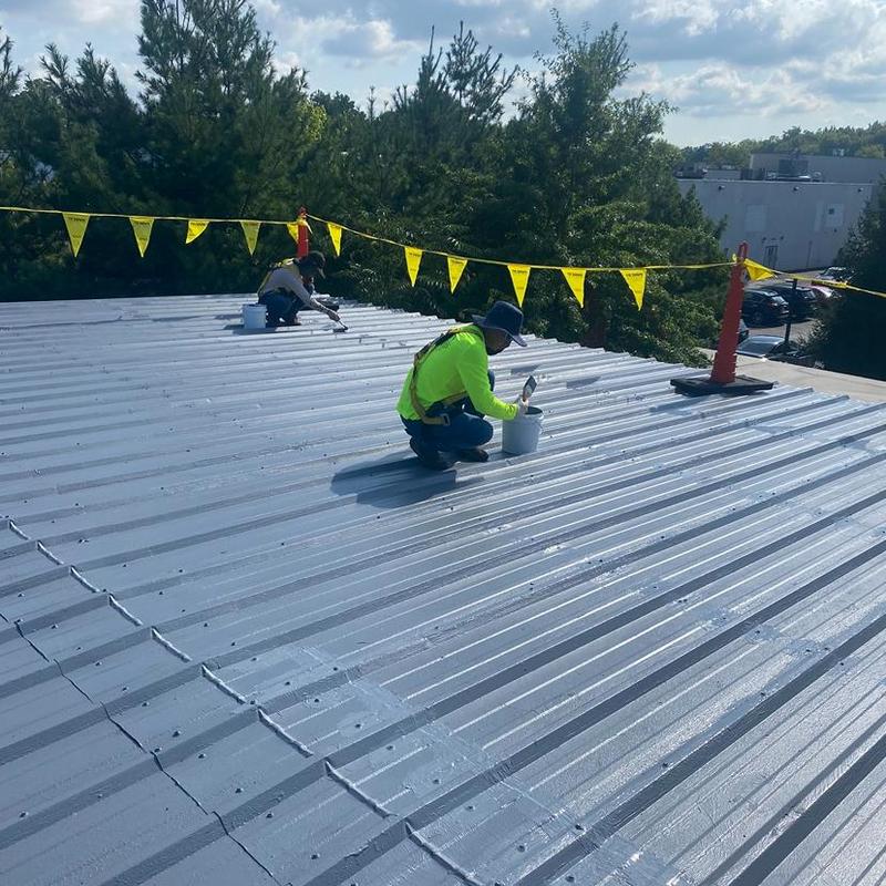 Metal roof coating application with safety barriers Metal roof coating application with safety barriers