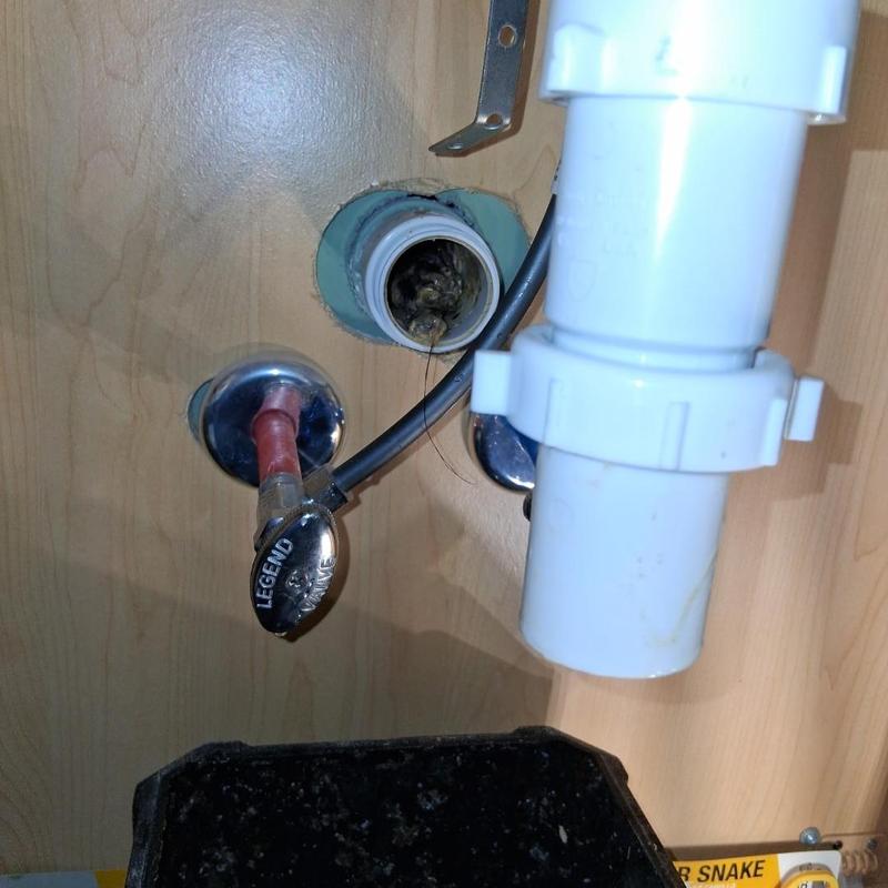 Vanity drain pipe with clog removal tools under sink