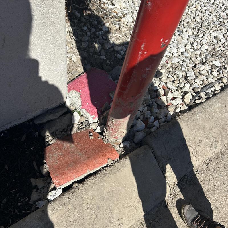 Irrigation system pipe near concrete curb and gravel