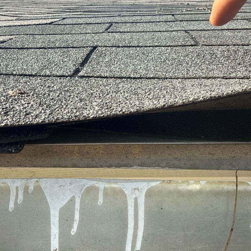 Asphalt shingles lifting showing hail damage and flashing issues