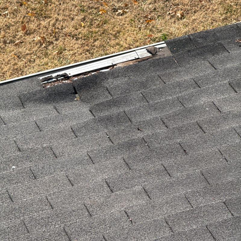 Asphalt shingles and roof edge damage on residential roof