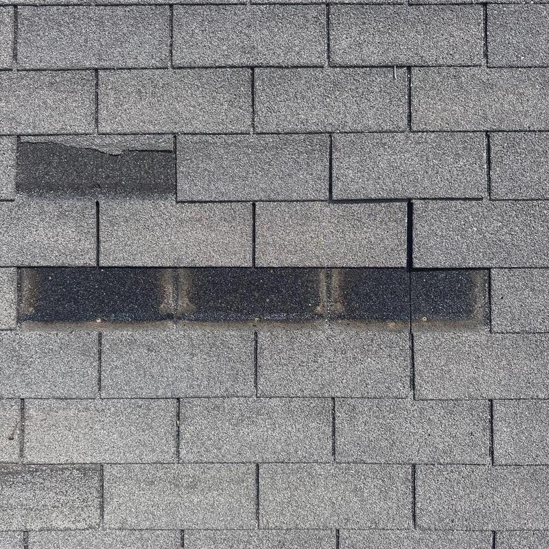 Asphalt shingles with visible damage and discoloration