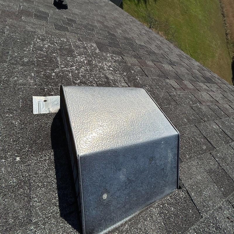 Roof vent with hail-damaged shingles and ridge caps