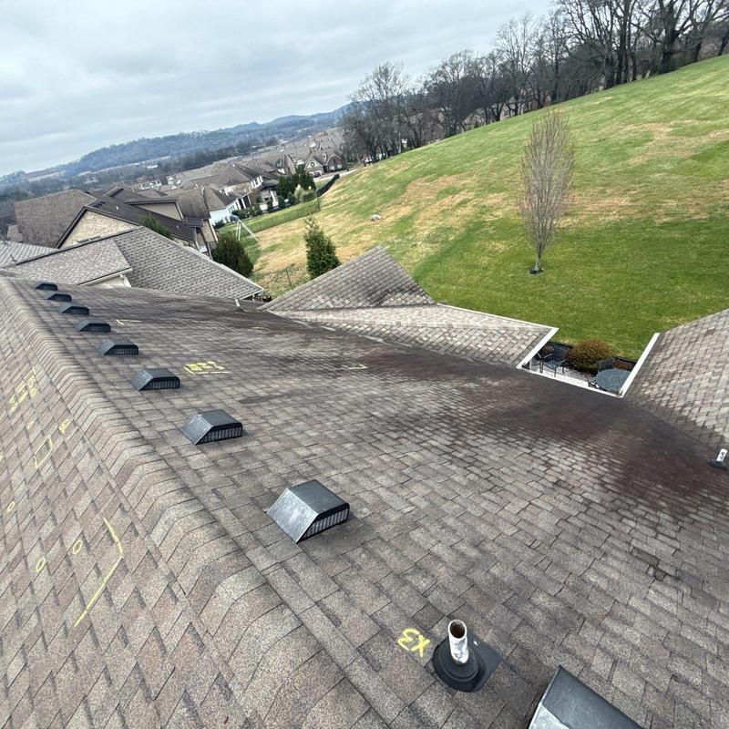 Asphalt shingles with yellow inspection markings on roof