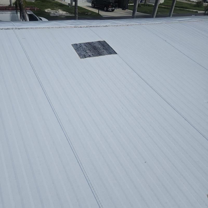 Metal roof panel with worn patch section visible