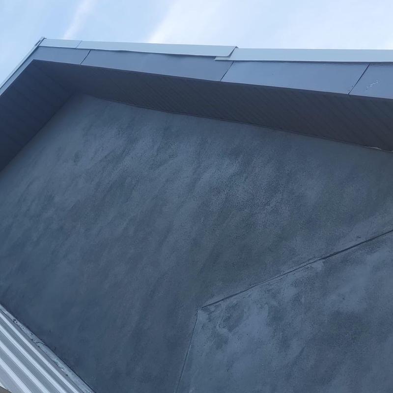 Flat roof surface and metal flashing with wind damage