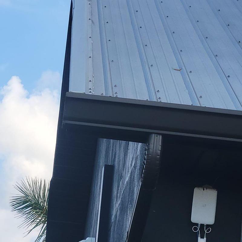Metal roof edge and gutter inspection in Florida home