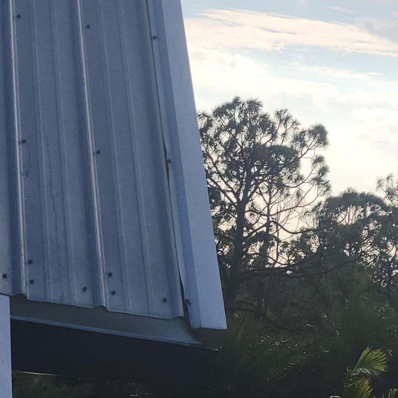 Metal roof panel showing wind damage at edge