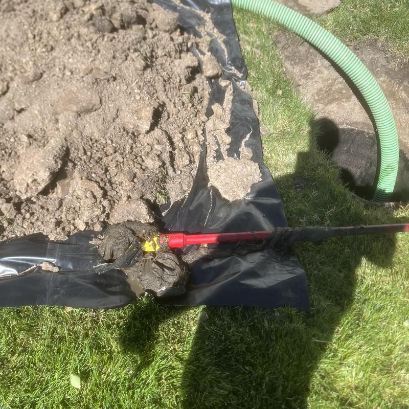 Septic tank sludge and inspection tool on black tarp
