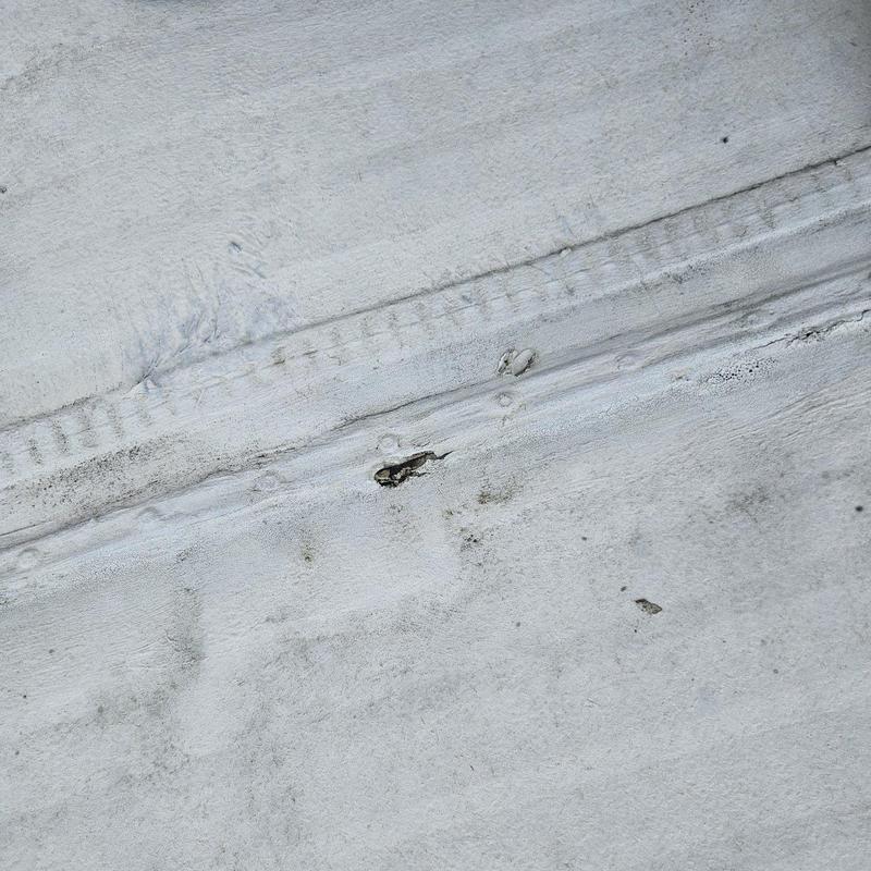 Flat roof membrane with tear and damage closeup Flat roof membrane with tear and damage closeup