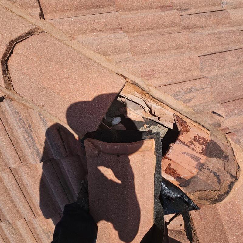 Tile roof damaged section with broken tiles and exposed underlayment Tile roof damaged section with broken tiles and exposed underlayment