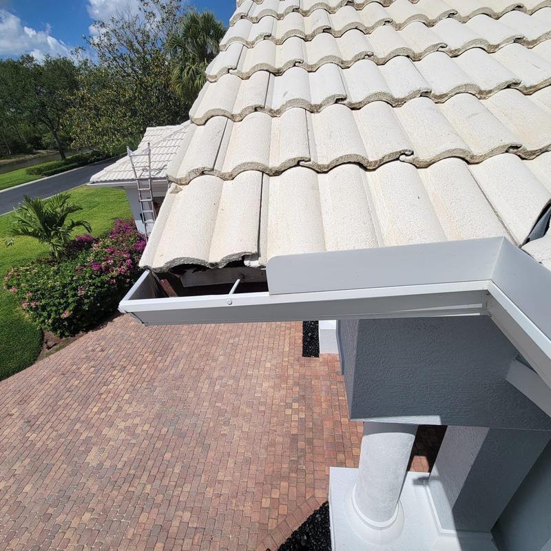 Concrete tile roof with broken tiles and damaged gutter