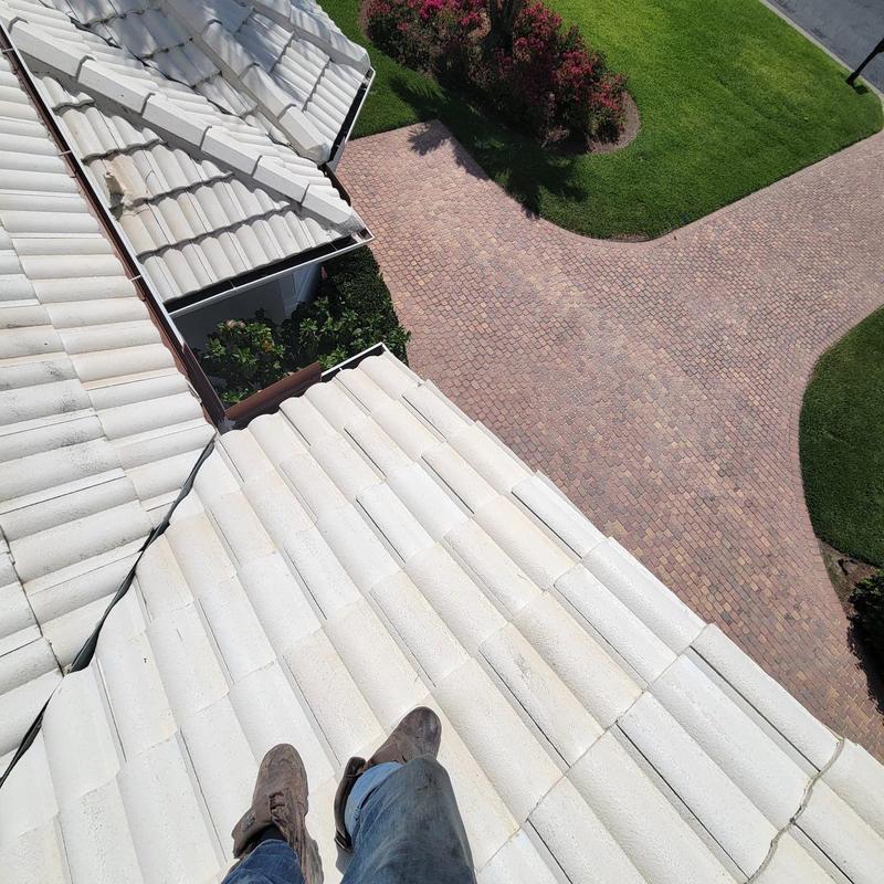 Concrete tile roof with visible wear near driveway