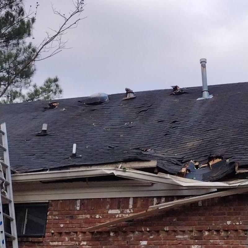 Asphalt shingle roof with severe storm damage Asphalt shingle roof with severe storm damage