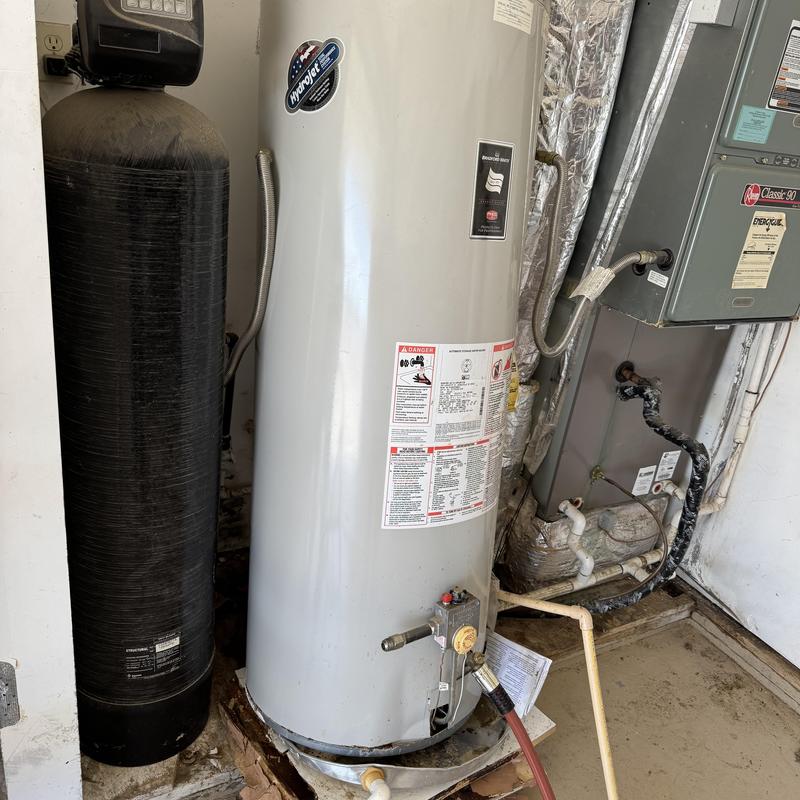 65-gallon water heater with rusted base in garage