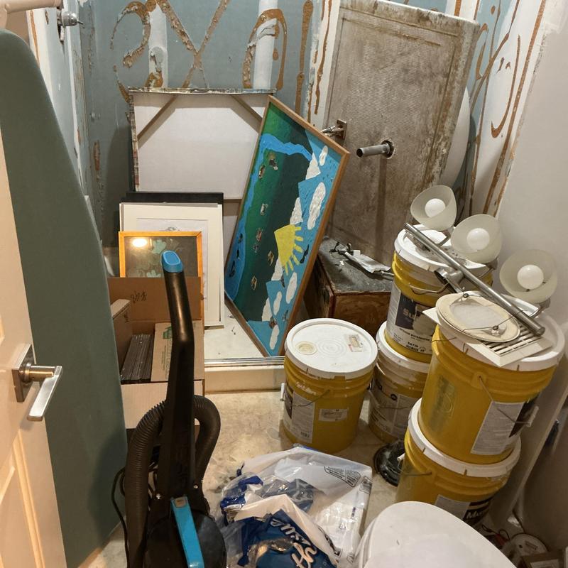 Painting supplies storage with buckets and framed art