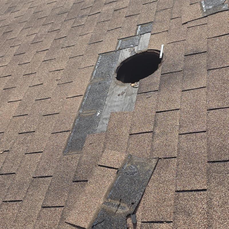 Roof shingles with circular hole and hail damage