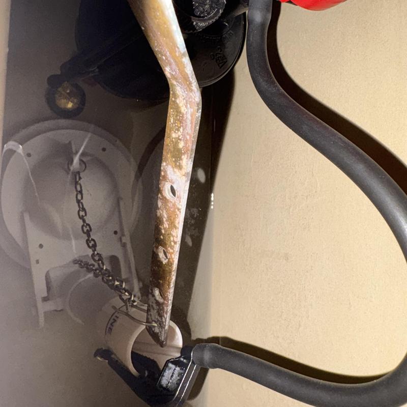 Toilet flush lever and chain in tank close-up