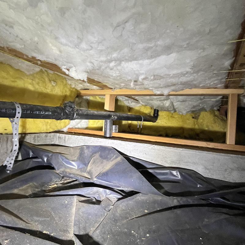 PVC drain pipe in insulated crawl space with vapor barrier