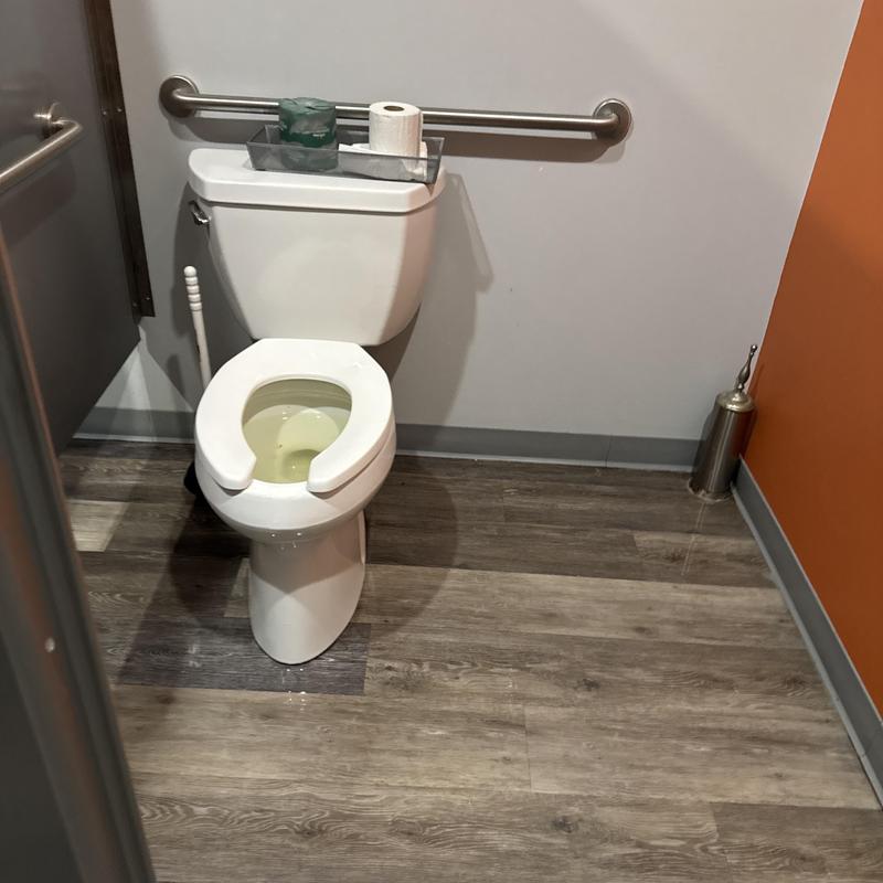 Commercial toilet with opened seat in restroom stall Commercial toilet with opened seat in restroom stall