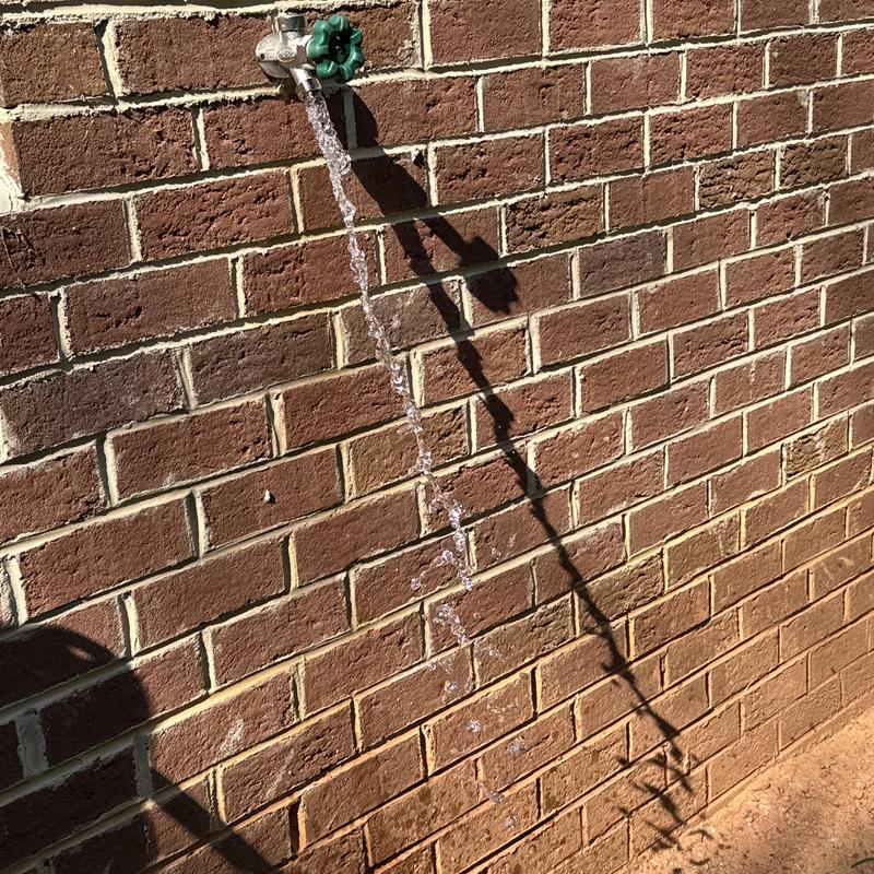Frost proof hose bib with running water on brick wall Frost proof hose bib with running water on brick wall