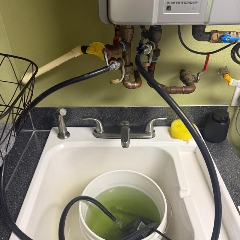 Tankless water heater flushing with hoses and bucket
