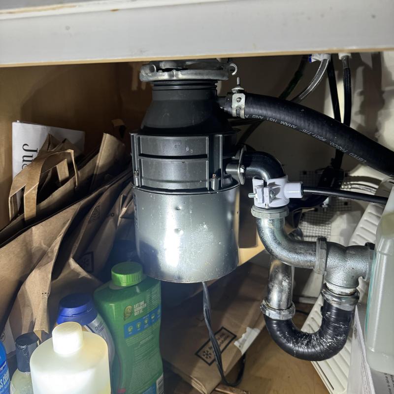 Garbage disposal unit with plumbing connections under sink