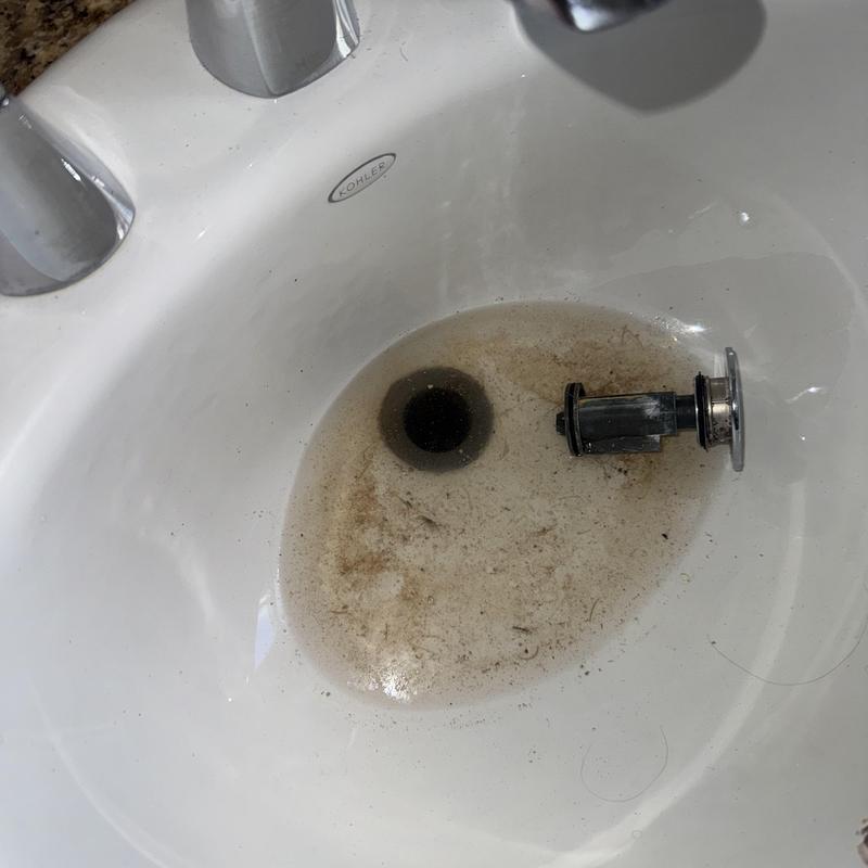 Basin drain with removed stopper and dirty water