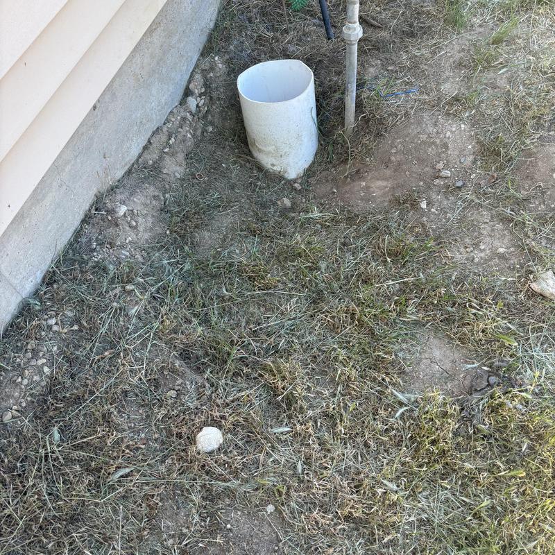 Irrigation valve riser and backflow assembly outside home