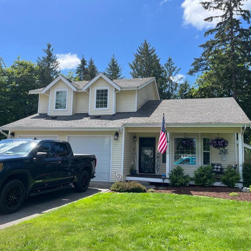 Asphalt shingle roof on two-story house with truck Asphalt shingle roof on two-story house with truck